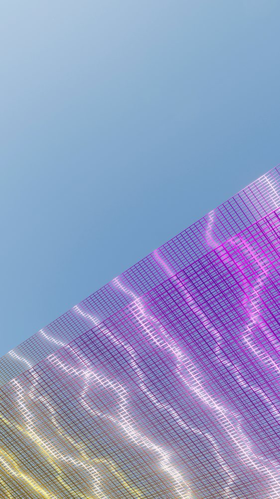 Mesh fabric with purple and yellow hues against a blue sky background.