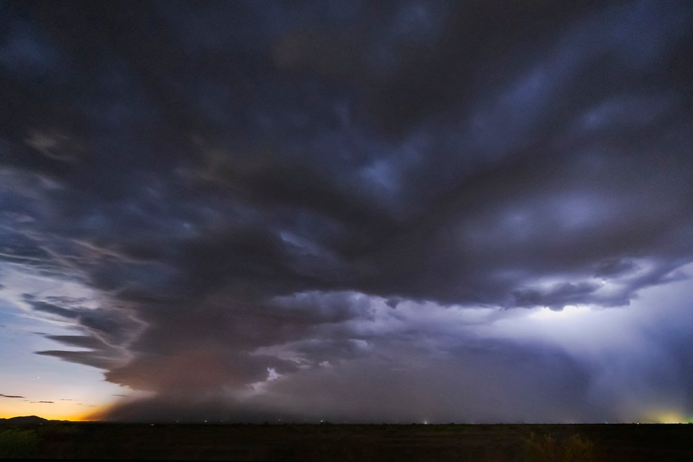 Evening Thunderstorm with a Haboob dust storm observed, showing dark clouds and dust obscuring the horizon at sunset, Storm Chasing, Weather, Environmental Issues, McNeal, Arizona, USA.