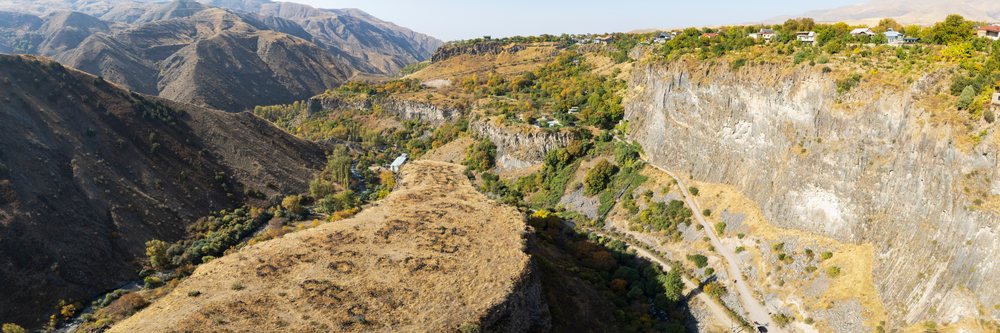 Panoramic view of a mountainous valley with cliffs, river, and autumn foliage, Goght Village, Kotayk Province, Armenia.