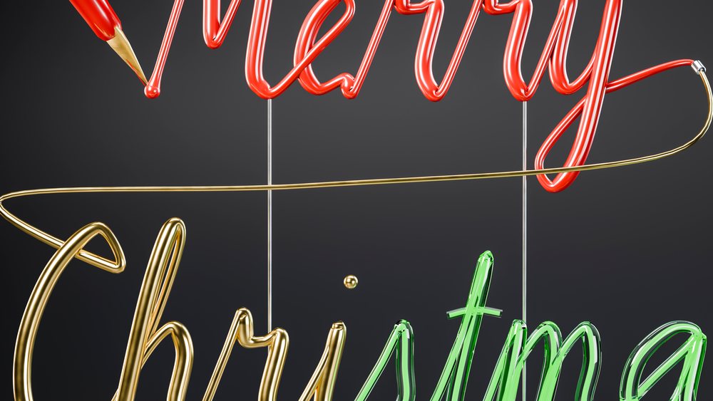 Neon lights spell 'merry christmas' in red, gold, and green glowing against a dark background.