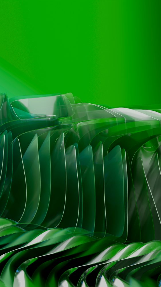 Transparent abstract glass sculpture with wavy curved shapes and green background in studio environment.