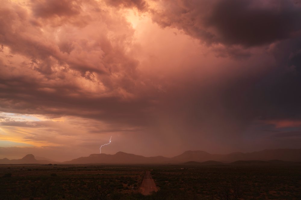 Storm laden with dust from a Haboob and visible lightning bolt over mountains at sunset, Storm Chasing, Weather, Environmental Issues, Douglas, Arizona, USA.