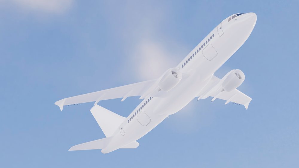 White commercial airplane flying in a clear blue sky, showing detailed aircraft wings and engines.