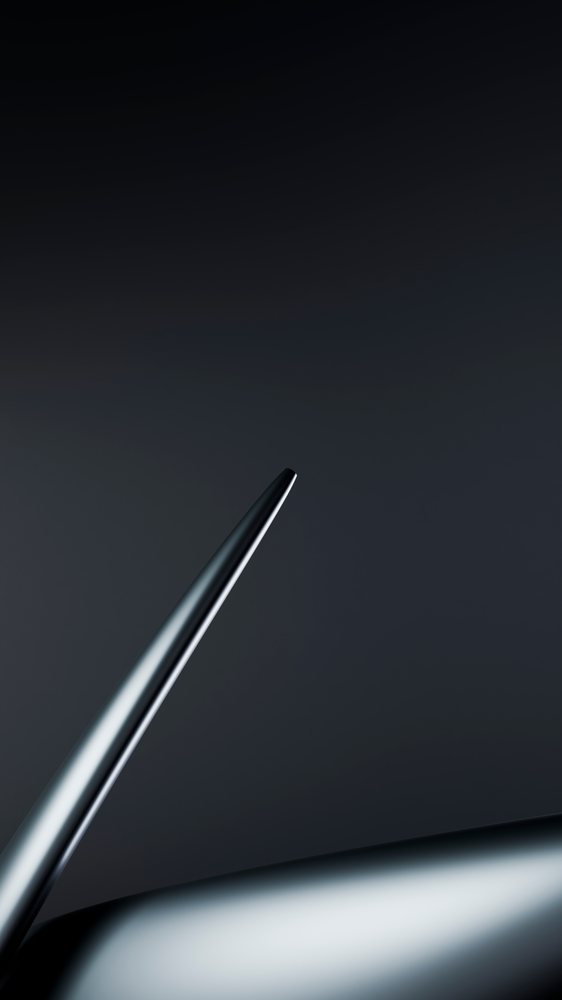 Abstract closeup of a smooth metallic curved surface with a dark background, emphasizing sleek modern design.