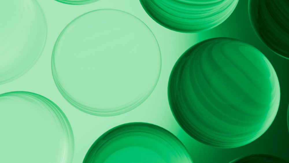 Abstract digital illustration showing green transparent spheres clustered with overlapping and gradient shading.