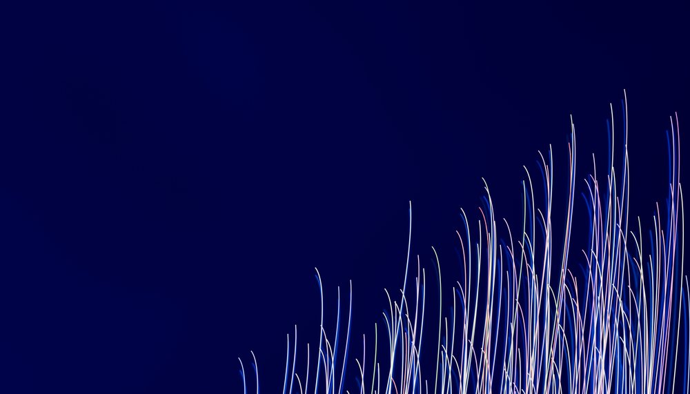 Light streaks with colorful vertical lines against a dark blue background creating an abstract pattern.