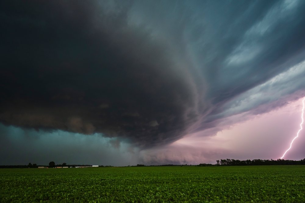 Supercell storm with lightning striking over a green flat field, in the Great Plains, Weather, Environmental Issues, Storm Chasing, Charlestown, Illinois, USA.