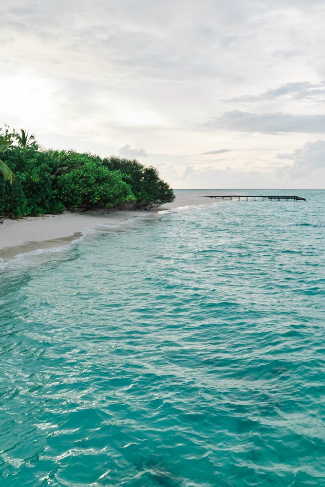 A tropical island beach with a pier in a beach