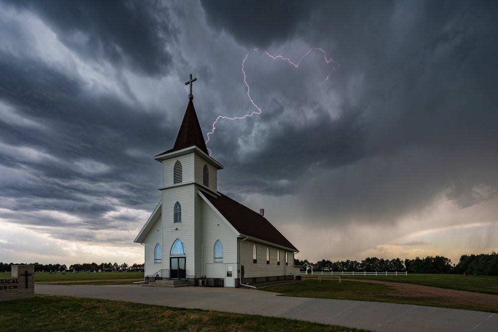 Lightning strike near Berea Evangelical Lutheran Church under dark storm clouds, Chappell, Nebraska, USA.