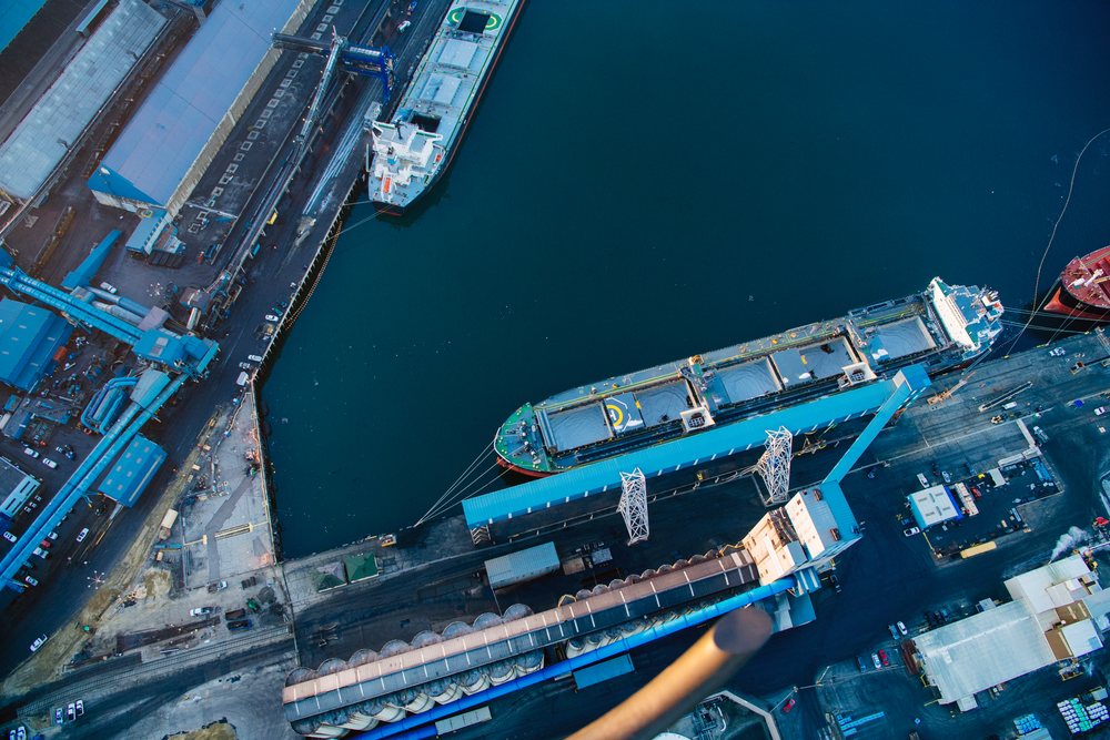 Cargo ship docked at a loading dock with industrial facilities at a major port in Long Beach, major port in Long Beach, CA, USA.