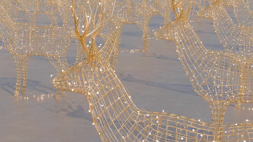 Wireframe deer decorations with small festive lights arranged outdoors.