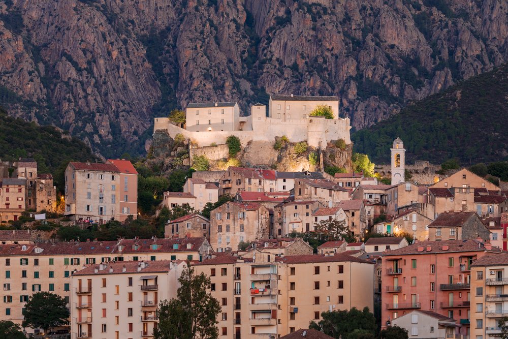 The Citadel of Corte sits on a hilltop above the historic town at Dawn, with rocky mountains rising behind, Travel Photography, Corsica, France.