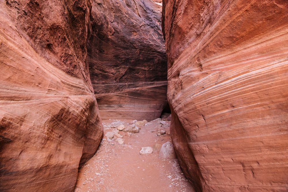 Slot canyon featuring towering sandstone rock walls and a sandy ground, Buckskin Gulch, Utah, USA.