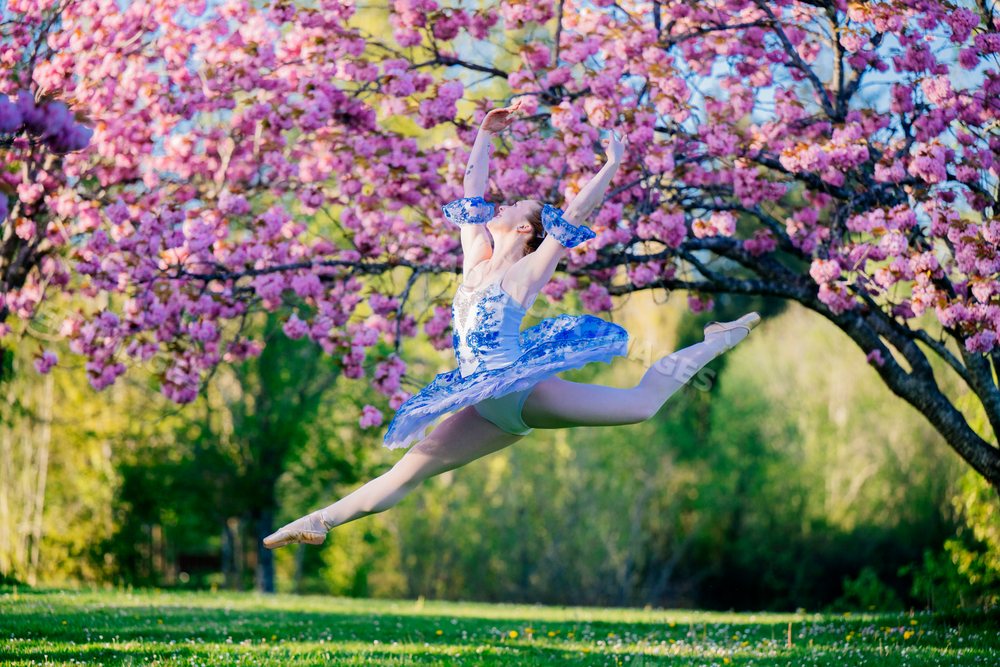 A dancer leaps gracefully outdoors