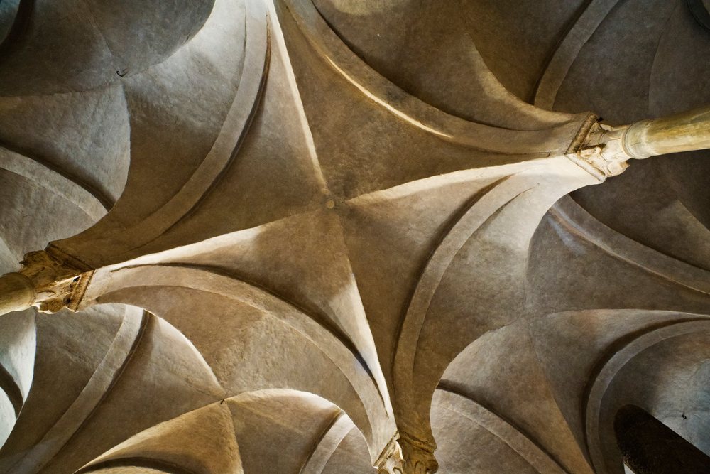 Vaulted stone ceiling with arches and columns inside Basilica di San Miniato al Monte, Florence, Italy.