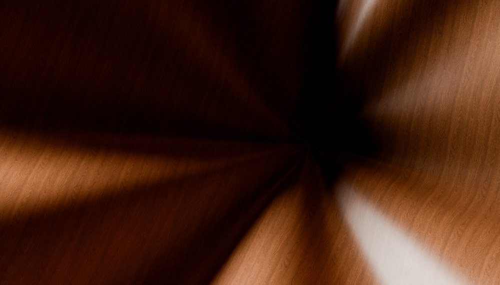 Radial blur effect on brown wood grain texture highlighting natural wood patterns and surface detail.