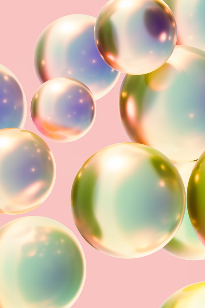 Floating iridescent pearl-like spheres with soft pastel colors and light reflections on a pink abstract background.