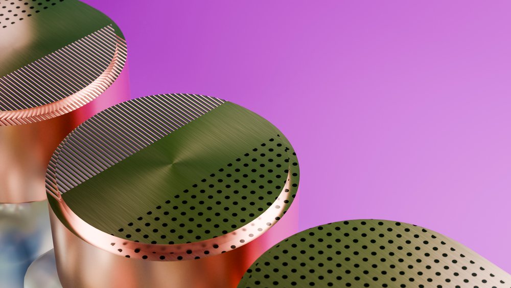 Three metallic cylindrical capsules with perforated dots and stripes on a pink background.