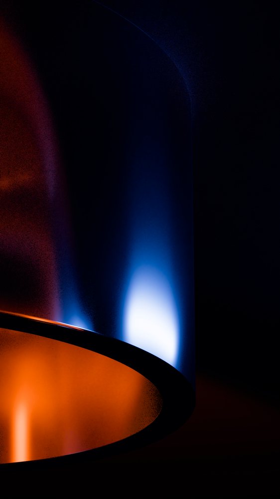 Abstract modern art featuring curved shapes illuminated by blue and orange light gradients against a dark background.