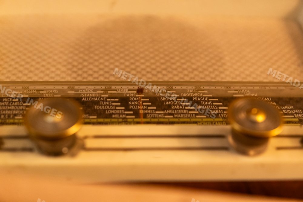 Close-up of a vintage radio tuner dial with european city names