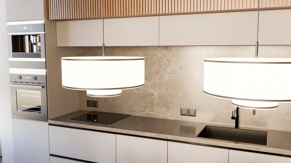 Modern kitchen interior featuring countertop with gray surface, induction cooktop, integrated sink, built-in stainless steel oven and coffee machine, with pendant lights above.