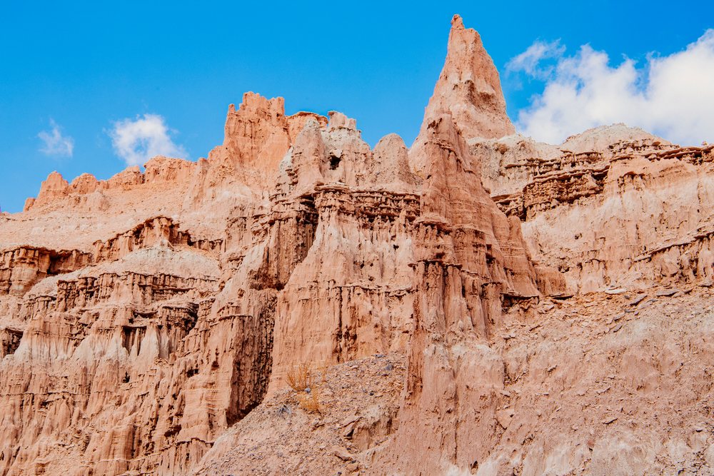 Rock formations and natural cliffs with red and tan rocks rise under a blue sky in a desert landscape, national park, Cathedral Gorge State Park, Nevada, USA.