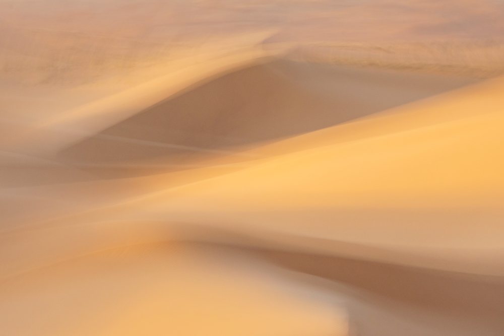 Sunlit sand dunes with shadows create an abstract desert landscape in Erg Lehoudi, Lifestyle, Culture, M'hamid, Zagora Province, Morocco.