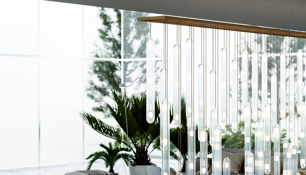 Modern chandelier with glass pendant lights hangs over a contemporary living room.