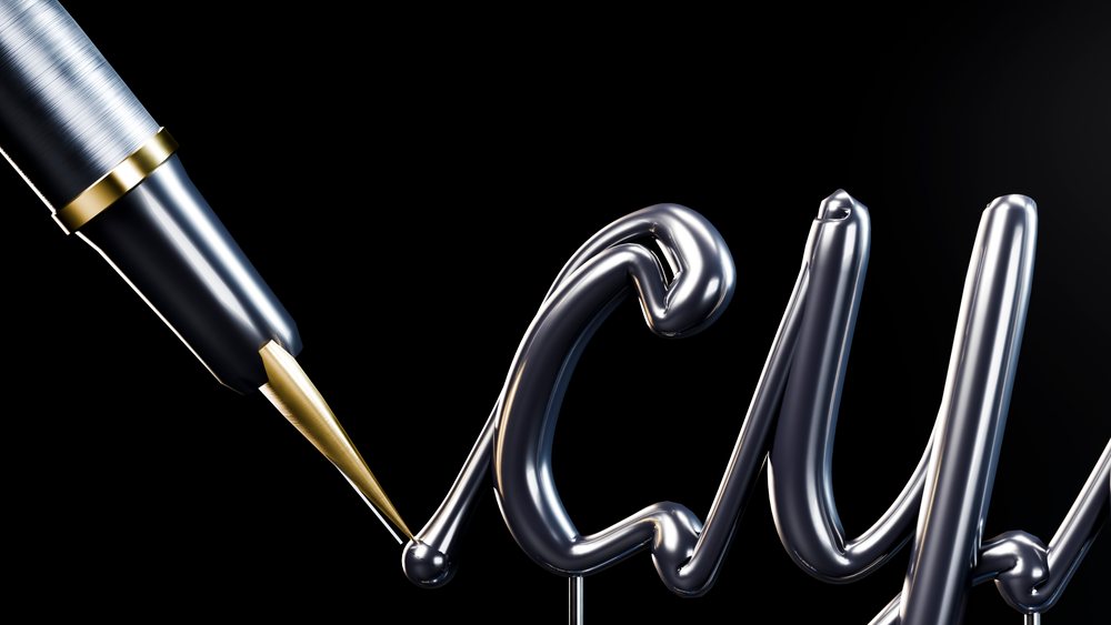 Metallic fountain pen writes elegant calligraphy script on a dark background.