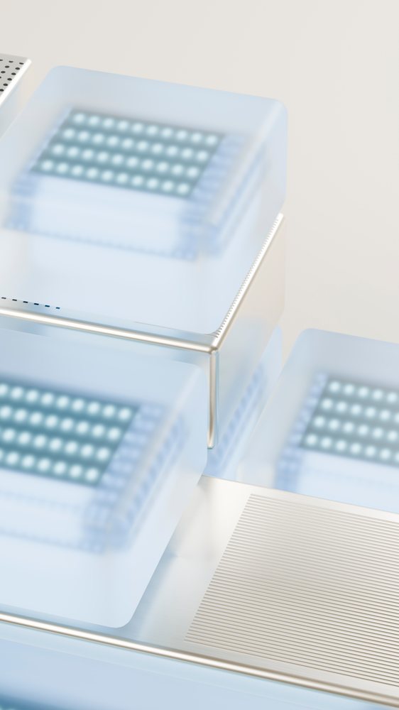 Close-up of square microchips covered by translucent silicone cases mounted on a metal frame in a technology setup.