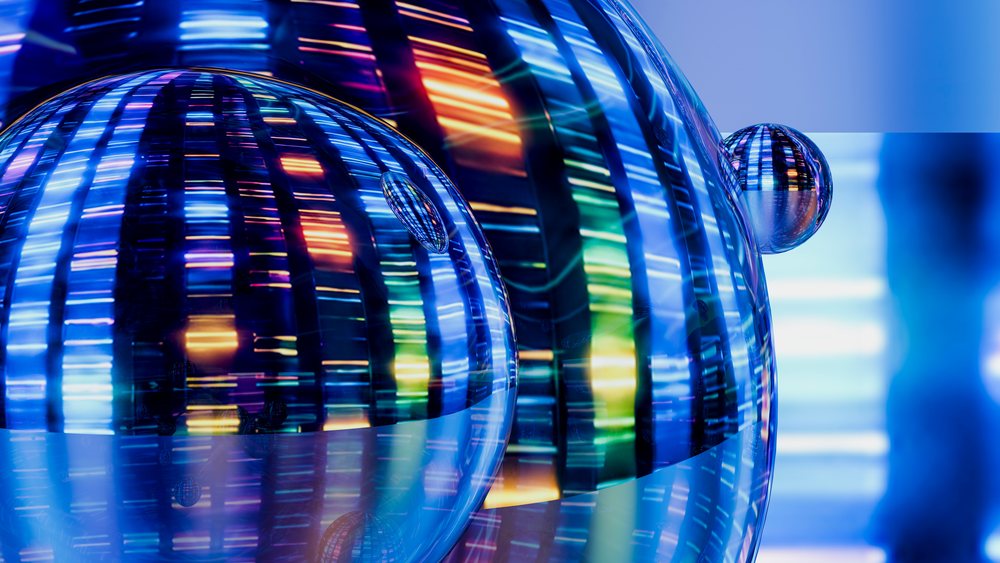 Glass spheres reflecting colorful light stripes and patterns on a dark background.