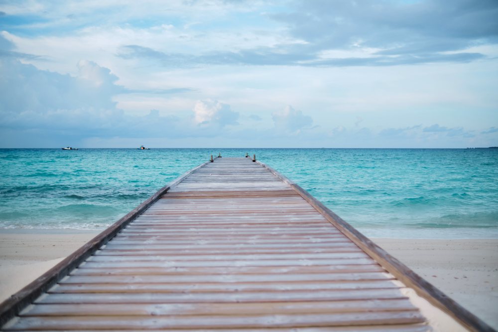 A wooden pier leading into the turquoise ocean