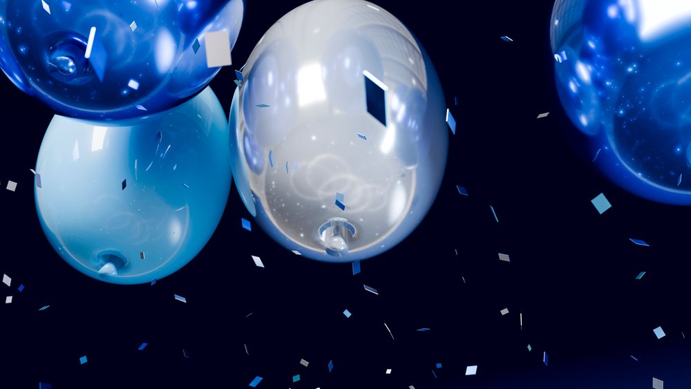 Blue and silver shiny balloons float above multi-colored square confetti on a dark background, creating a festive party atmosphere.