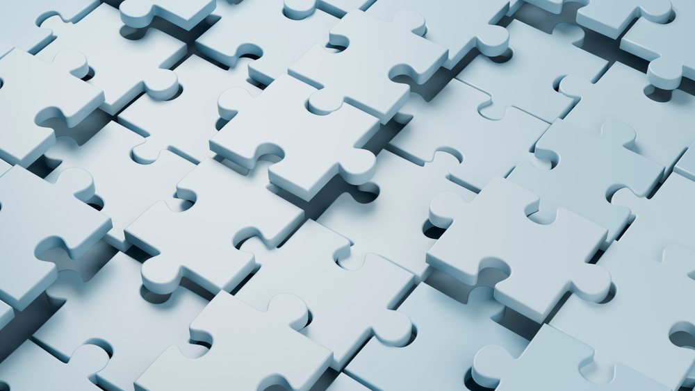 Three-dimensional blue puzzle pieces interlock to form an abstract geometric pattern in close-up view.