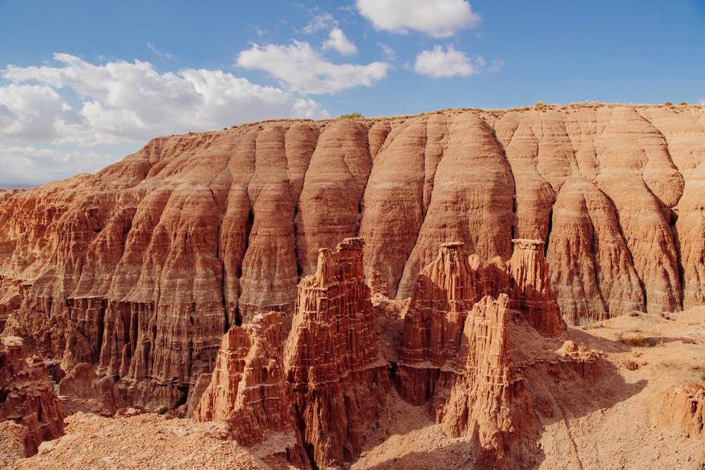 Rock formations and cliffs with erosion patterns at Cathedral Gorge State Park in Nevada under a partly cloudy sky, USA.