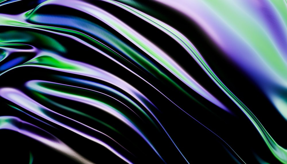 Abstract colorful fluid waves with purple and green tones on a dark reflective surface.