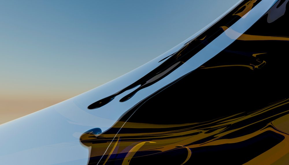 A close-up view of flowing black reflective liquid with smooth curves