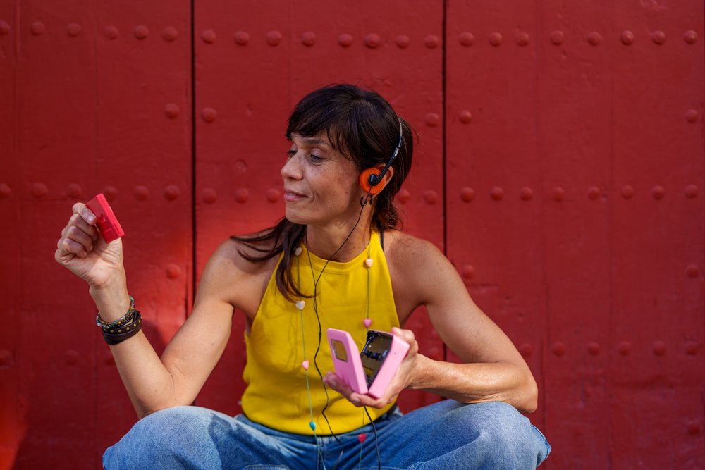 Woman listening to music outdoors with headphones and cassette player, retro, vintage, Málaga, Spain.