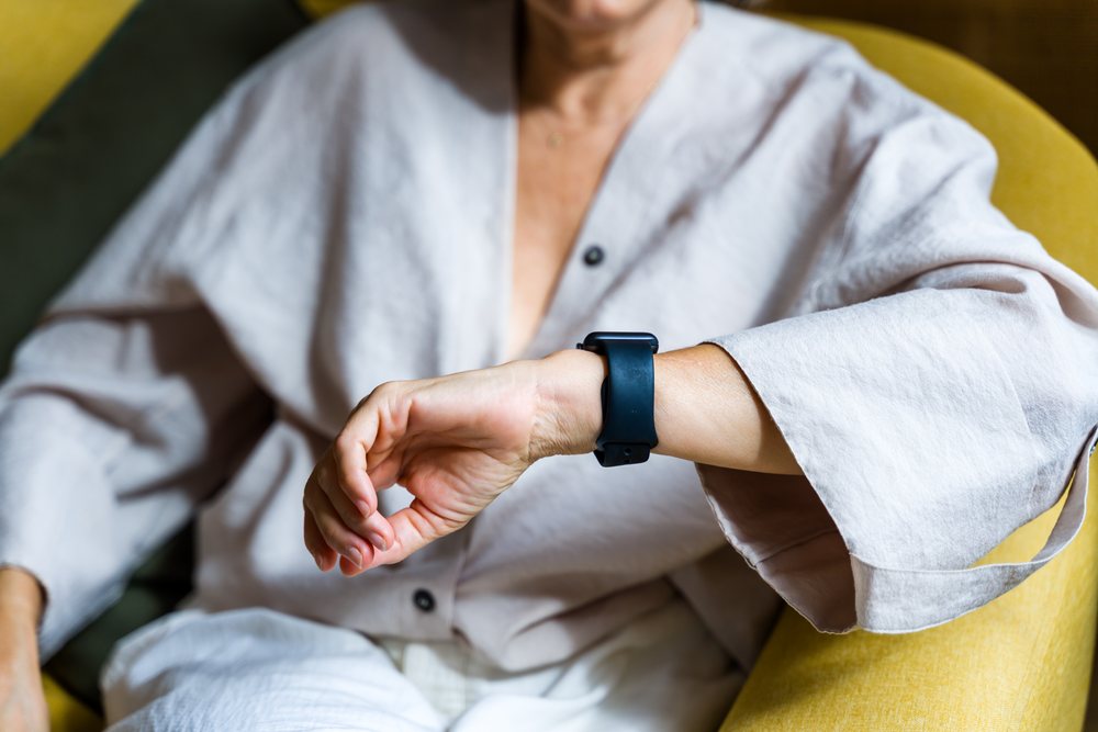 Person wearing a smartwatch on their wrist while seated indoors, Spain.