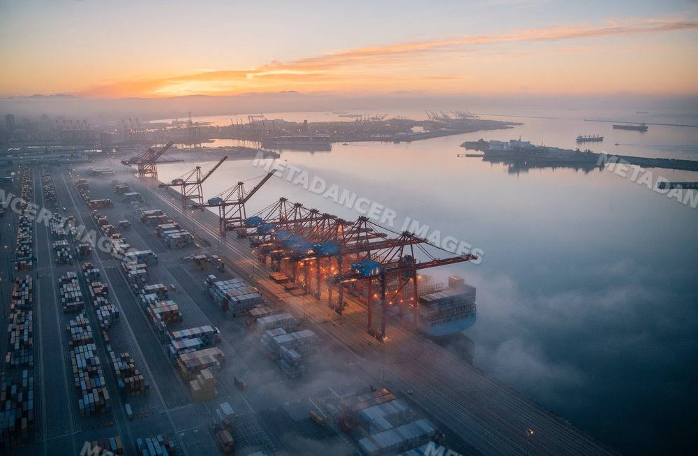 Container port with cranes loading cargo at sunrise in Long Beach
