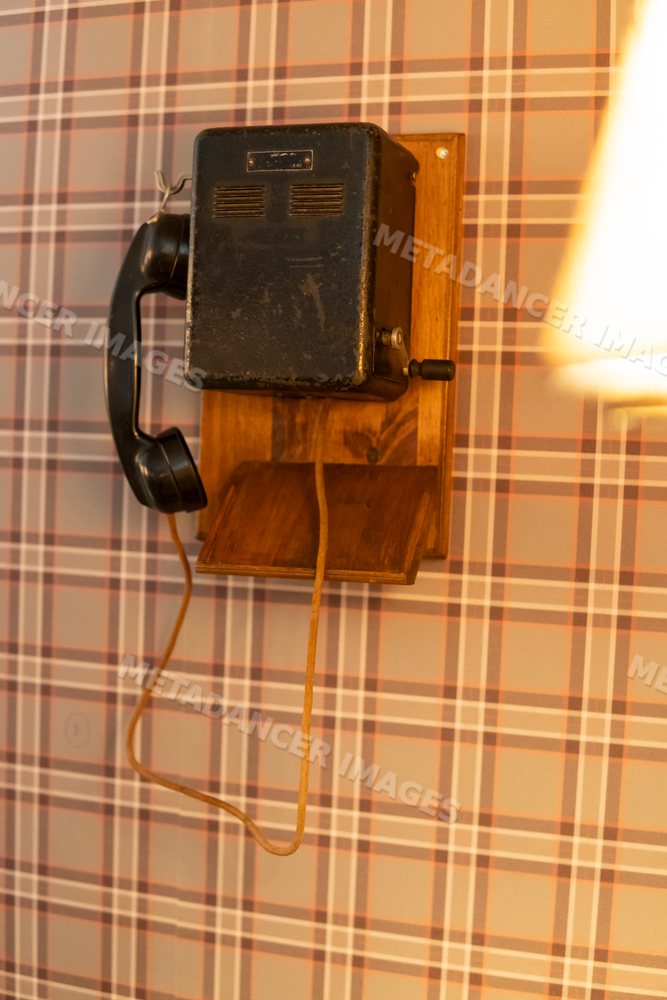 Vintage corded telephone mounted on wooden base in retro setting