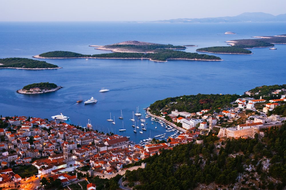 Town of Hvar with red rooftops and harbor with boats, Dusk, Croatia.