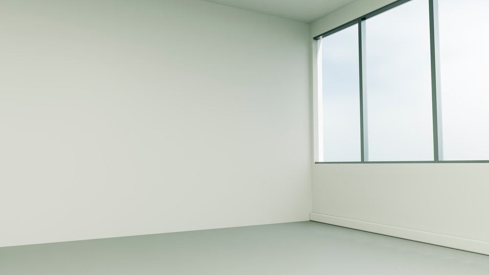 Empty room corner with large windows letting in natural light and minimalist design.