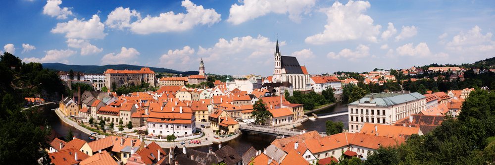 Panorama of Cesky Krumlov town, showing historic buildings with red tile roofs along the river, Bohemia, Czech Republic.