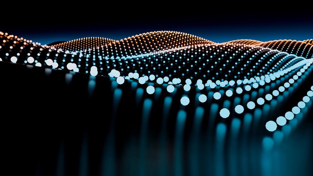 Abstract digital illustration of a flowing wave formed by glowing orange and blue light dots on a dark background.