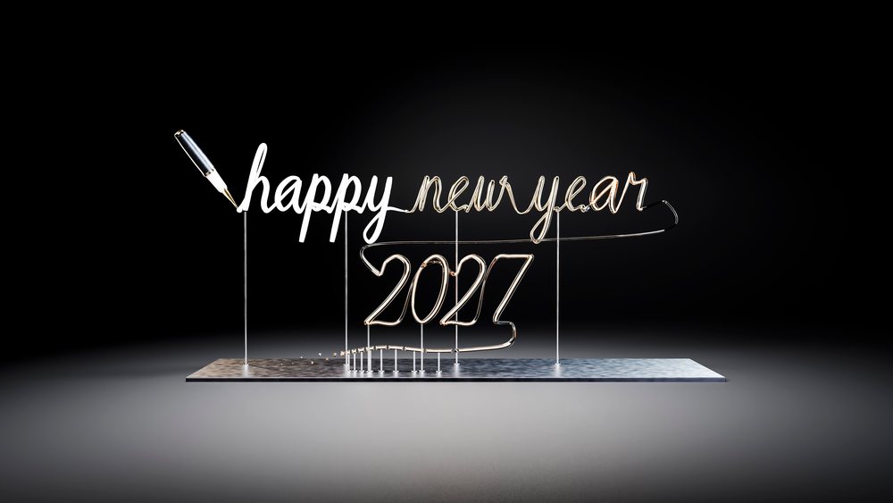 Wire sculpture forming cursive text 'happy new year 2027' on a metal base with pen tip against black background.