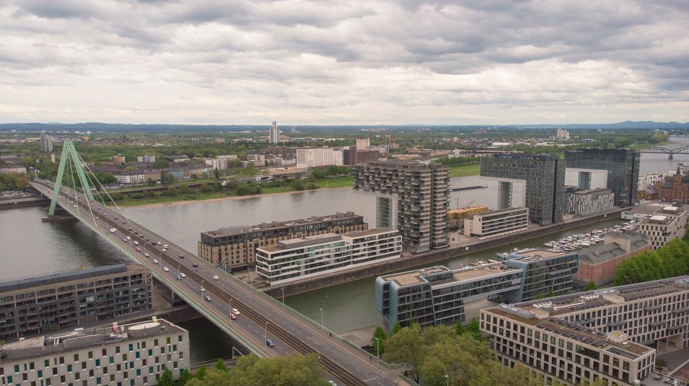 Bridge over ariver Rhine with surrounding modern residential and office buildings in a historic district of Cologne, North Rhine-Westphalia, Germany.