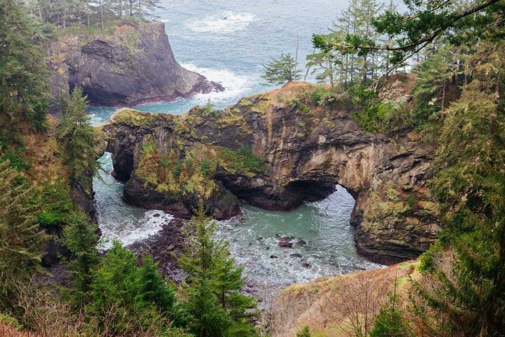 Sea arch rock formation spans rocky cliffs along the Oregon coastline, Boardman State Scenic Corridor, USA.