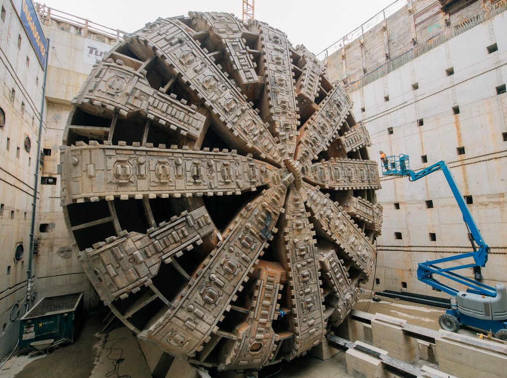 A large tunnel boring machine with a circular cutting head positioned inside a deep construction pit, a large tunnel boring machine, drilling, USA.
