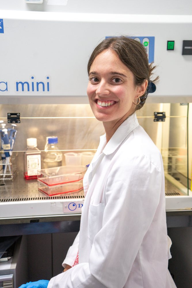 Female scientist in a white lab coat working with biological samples inside a biohazard cabinet in a laboratory, research, biology, Seville, Andalucía.